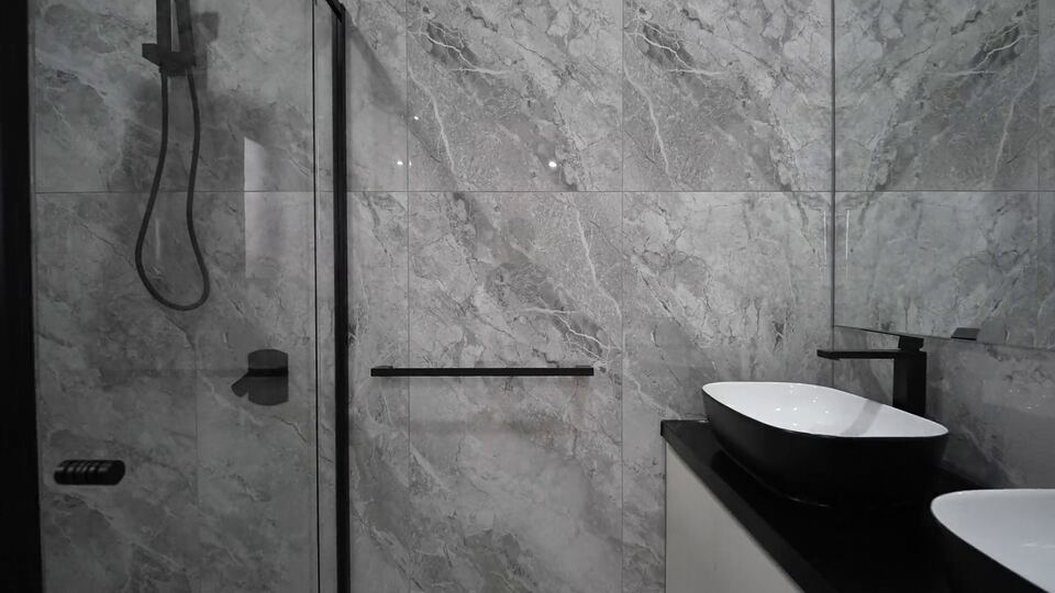 Shower with grey marble-look tiles, a black rail shower and a frameless glass screen
