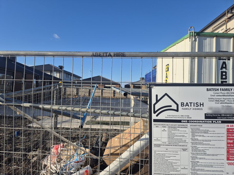 Batish Family Homes site sign on the fence at Jagged Circuit, listing the builder registration and building permit details