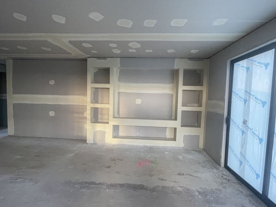 Living area at Lucania Crescent with plasterboard set and the built-in TV wall niches formed